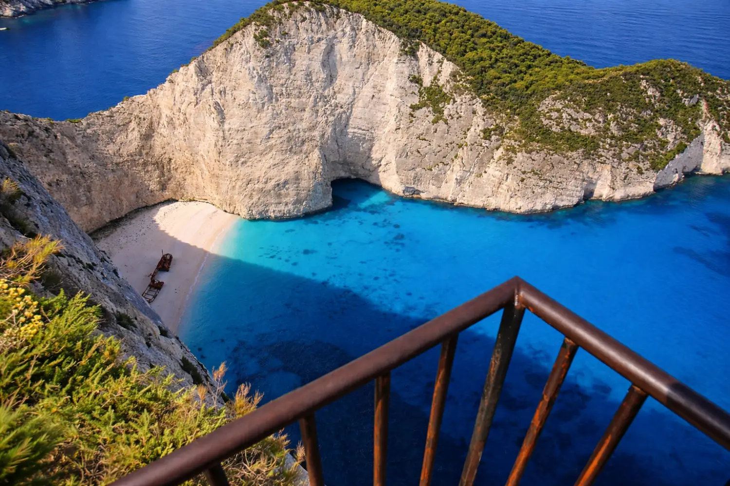 Viewpoint platform on the clifftop above the cove, with the MV Panagiotis Shipwreck visible far below in turquoise water